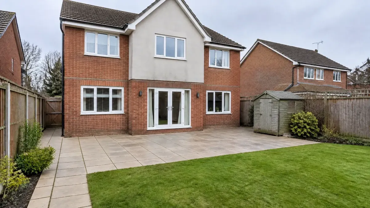 After: the same fenced Essex garden with clean patio slabs, tidy joints and a bright lawn