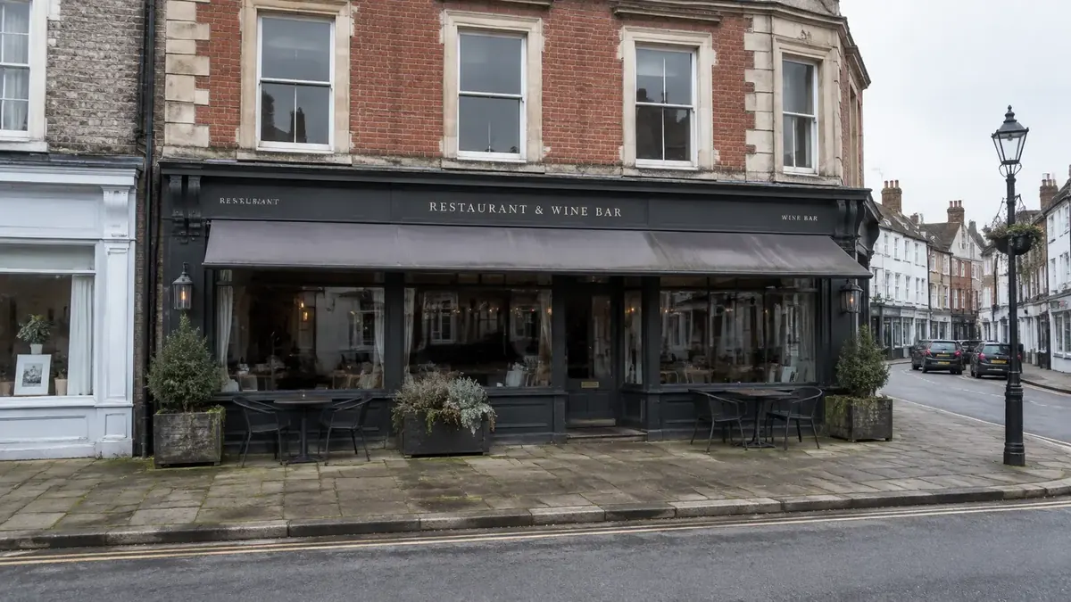 Before: weathered dark restaurant frontage with stained paving on an English market-town high street